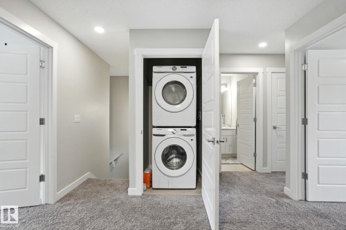 Utility area featuring a stacked washer and dryer, recessed lighting, and carpeted flooring - 6260 175 Avenue, Edmonton, AB - Indoor Photo Showing Laundry Room