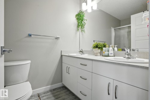 Bathroom featuring a dual vanity with white cabinetry and a light-colored countertop - 6260 175 Avenue, Edmonton, AB - Indoor Photo Showing Bathroom