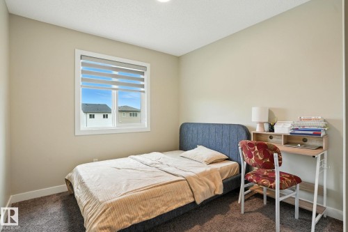 This room features neutral-toned walls, a window with horizontal blinds, and a textured carpet - 6260 175 Avenue, Edmonton, AB - Indoor Photo Showing Bedroom