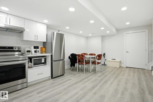 The kitchen features white cabinetry, stainless steel appliances, and a tiled backsplash - 6260 175 Avenue, Edmonton, AB - Indoor Photo Showing Kitchen
