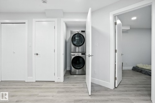 This property includes a dedicated laundry area with a stackable washer and dryer, featuring light-colored flooring - 6260 175 Avenue, Edmonton, AB - Indoor Photo Showing Laundry Room