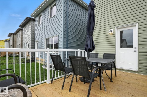 The property features a spacious wooden deck with white railings, offering views of a grassy area - 6260 175 Avenue, Edmonton, AB - Outdoor With Deck Patio Veranda With Exterior