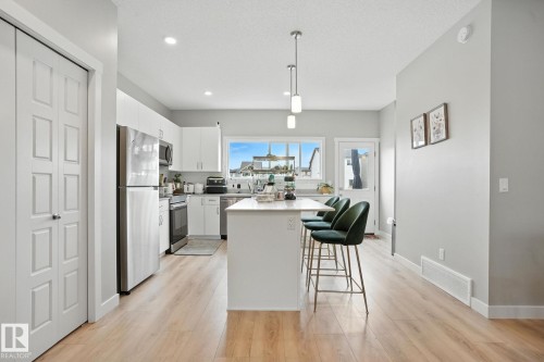 The kitchen features light-colored flooring, white cabinetry, and stainless steel appliances - 6260 175 Avenue, Edmonton, AB - Indoor Photo Showing Kitchen