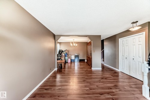 Spacious interior featuring wood-finish flooring, neutral-toned walls, and a recessed archway - 9845 184 Street, Edmonton, AB - Indoor Photo Showing Other Room