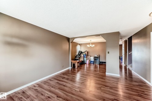 Spacious interior room featuring wood-finish flooring, neutral wall paint, and white trim - 9845 184 Street, Edmonton, AB - Indoor Photo Showing Other Room