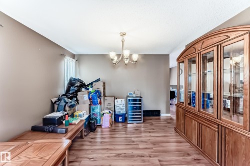 Dining area featuring wood-finish flooring, a contemporary chandelier, and neutral wall tones - 9845 184 Street, Edmonton, AB - Indoor Photo Showing Other Room