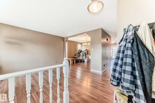 Interior space featuring wood-finish flooring, a white spindle railing, and neutral wall tones - 9845 184 Street, Edmonton, AB - Indoor Photo Showing Other Room