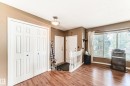 Spacious entryway featuring wood-finish flooring, a bi-fold closet, multiple windows with blinds, and an overhead flush mount light fixture - 9845 184 Street, Edmonton, AB  - Indoor Photo Showing Other Room 