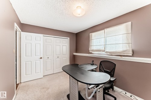 Carpeted room with a ceiling-mounted light fixture, dual windows featuring Roman shades, and a baseboard with chair rail molding - 9845 184 Street, Edmonton, AB - Indoor
