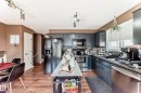 Kitchen featuring dark cabinetry, stainless steel appliances, a tiled backsplash, and wood-finish flooring - 9845 184 Street, Edmonton, AB  - Indoor Photo Showing Kitchen With Upgraded Kitchen 