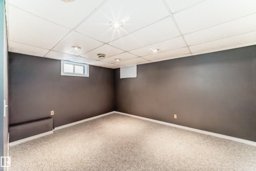 Finished room featuring light-toned carpeting, neutral painted walls, and a drop ceiling with recessed lighting - 9845 184 Street, Edmonton, AB - Indoor