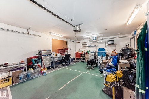 Garage space with green concrete flooring, overhead fluorescent lighting, and a built-in workbench area - 9845 184 Street, Edmonton, AB - Indoor Photo Showing Garage