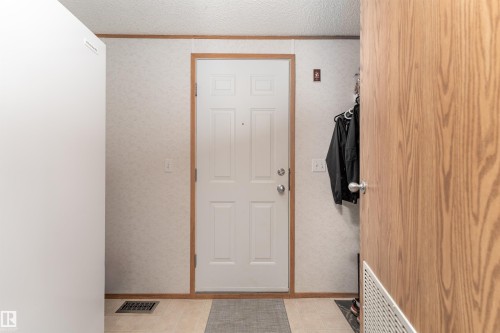 Entryway with a paneled white door, light-toned flooring, and wood trim details - 1663 Jubilee Crescent, Sherwood Park, AB - Indoor Photo Showing Other Room