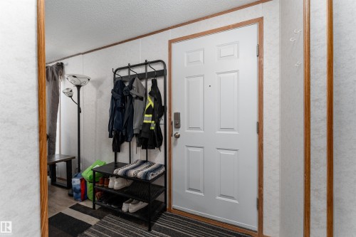 The property features a white paneled entry door with a door handle and deadbolt - 1663 Jubilee Crescent, Sherwood Park, AB - Indoor Photo Showing Other Room
