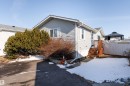 The property features a light-colored exterior with a front entry, wooden steps, and a compact front yard - 1663 Jubilee Crescent, Sherwood Park, AB  - Outdoor 