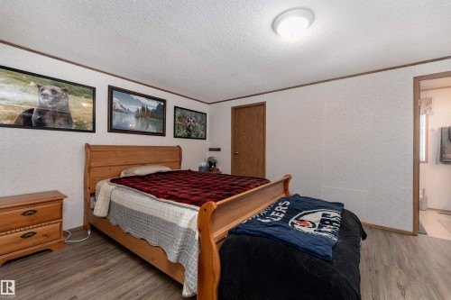 The property features an interior room with light-colored walls, a ceiling light fixture, and wood-toned trim - 1663 Jubilee Crescent, Sherwood Park, AB - Indoor Photo Showing Bedroom