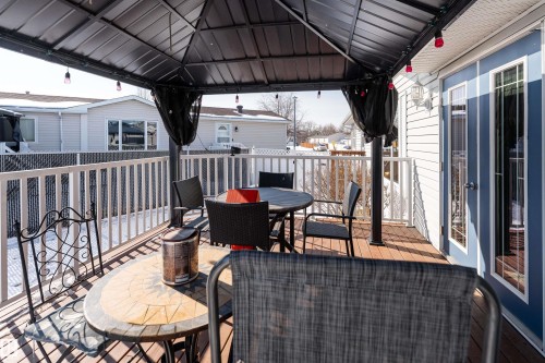The property features a spacious deck with wood-look plank flooring and a white railing - 1663 Jubilee Crescent, Sherwood Park, AB - Outdoor With Deck Patio Veranda With Exterior