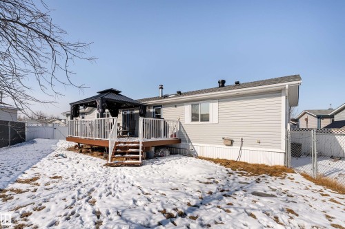 The property features a spacious rear deck with white railings, accessible via stairs - 1663 Jubilee Crescent, Sherwood Park, AB - Outdoor With Deck Patio Veranda
