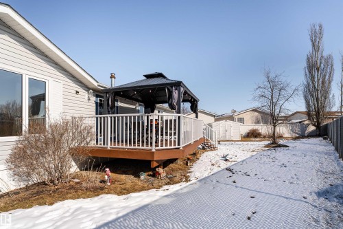 The property features a spacious deck with white railings and a dark gazebo, providing an inviting outdoor area - 1663 Jubilee Crescent, Sherwood Park, AB - Outdoor