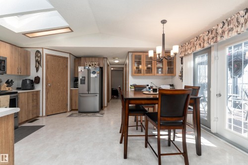 Open concept living area with light wood cabinetry, a skylight, and double doors providing access to the outdoors - 1663 Jubilee Crescent, Sherwood Park, AB - Indoor