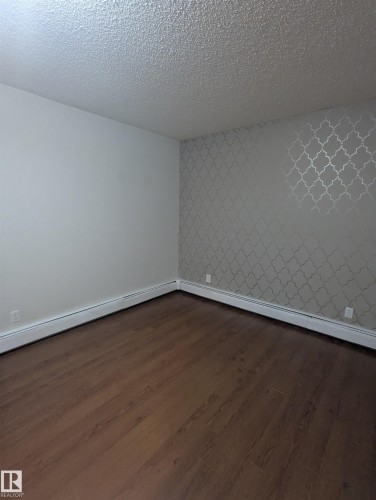 This room features wood-look flooring and a textured ceiling - 2 9140 149 Street, Edmonton, AB - Indoor Photo Showing Other Room
