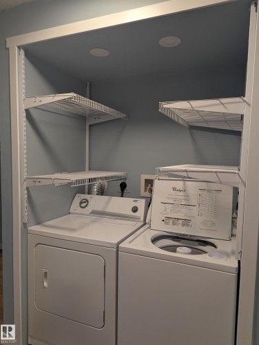 Laundry area with a washer, dryer, and wire shelving - 2 9140 149 Street, Edmonton, AB - Indoor Photo Showing Laundry Room