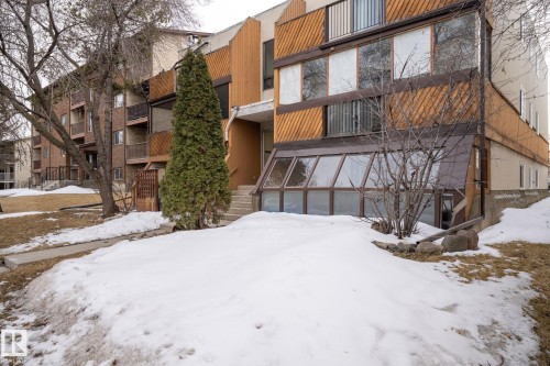 The property features a multi-story exterior with horizontal wood paneling and large windows, offering ample natural light - 2 9140 149 Street, Edmonton, AB - Outdoor