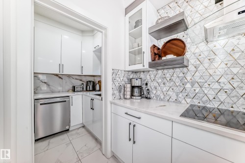 Contemporary kitchen featuring white flat-panel cabinetry and a patterned geometric backsplash - 17459 80 Street, Edmonton, AB - Indoor Photo Showing Kitchen