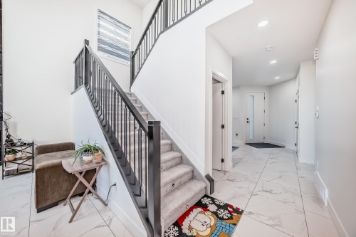 Carpeted staircase with dark iron balusters and handrails - 17459 80 Street, Edmonton, AB - Indoor Photo Showing Other Room