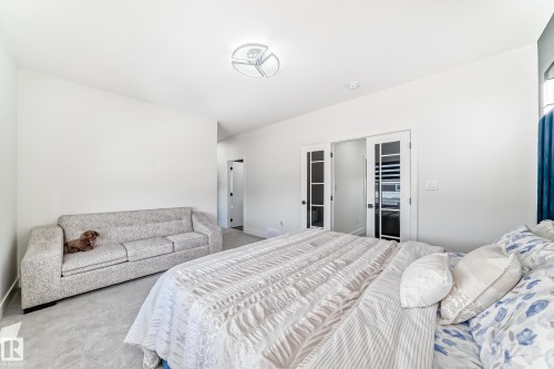 Spacious room featuring light gray carpet, recessed lighting, and a modern ceiling fixture - 17459 80 Street, Edmonton, AB - Indoor Photo Showing Bedroom