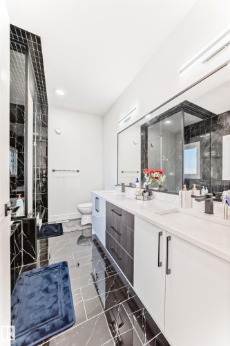 Bathroom featuring a dual vanity with white countertops, integrated sinks, and matte black fixtures - 17459 80 Street, Edmonton, AB - Indoor Photo Showing Bathroom