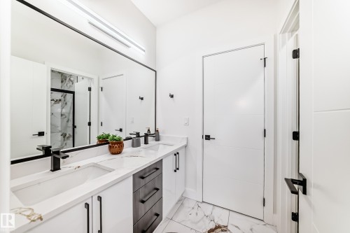 Bathroom featuring a dual vanity with undermount sinks, stone countertops, and matte black fixtures - 17459 80 Street, Edmonton, AB - Indoor Photo Showing Bathroom