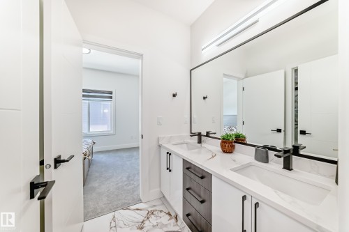 Modern bathroom featuring a dual-sink vanity with white cabinetry, dark wood-finish drawers, and black hardware - 17459 80 Street, Edmonton, AB - Indoor Photo Showing Bathroom