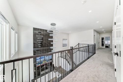 Upper-level landing featuring light gray carpeting, recessed lighting, and a contemporary multi-ring chandelier - 17459 80 Street, Edmonton, AB - Indoor Photo Showing Other Room