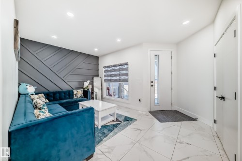 Entryway featuring large format marble-look tile flooring, a contemporary accent wall with geometric paneling, and recessed lighting - 17459 80 Street, Edmonton, AB - Indoor Photo Showing Other Room