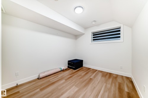 Spacious room with wood-finish flooring, crisp white baseboards, and a contemporary window with blinds - 17459 80 Street, Edmonton, AB - Indoor Photo Showing Other Room