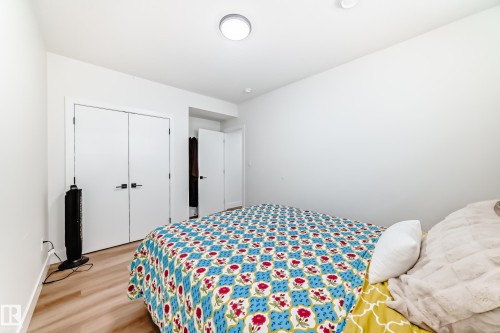 Light wood-finish flooring complements the bright white walls and trim - 17459 80 Street, Edmonton, AB - Indoor Photo Showing Bedroom