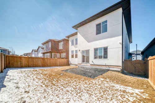 Rear exterior featuring a white stucco facade, black trim, and multiple windows - 17459 80 Street, Edmonton, AB - Outdoor