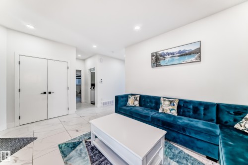 Spacious interior with large format white tile flooring and white baseboards - 17459 80 Street, Edmonton, AB - Indoor Photo Showing Living Room