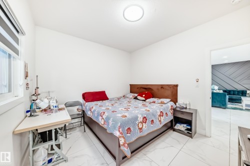 Bright room featuring white walls, large window with blinds, ceiling-mounted light fixture, and white tile flooring - 17459 80 Street, Edmonton, AB - Indoor Photo Showing Bedroom