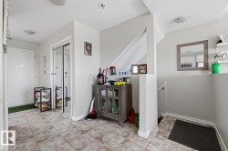 Tiled entry foyer featuring a mirrored closet, recessed lighting, and a neutral color palette - 
