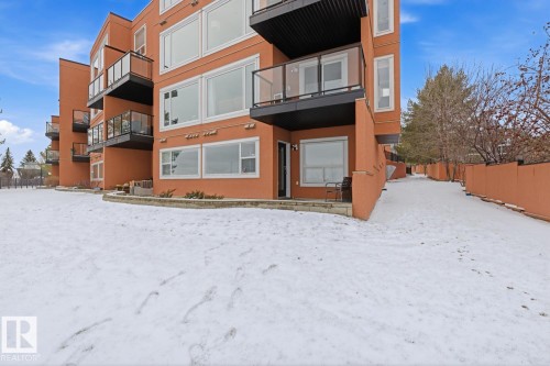 Multi-story building featuring an orange-hued exterior and multiple private balconies with glass railings - 115 10105 95 Street, Edmonton, AB - Outdoor With Balcony
