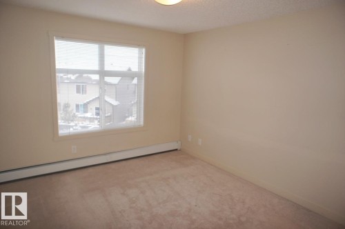 Neutral tone wall finishes - 326 6076 Schonsee Way, Edmonton, AB - Indoor Photo Showing Other Room
