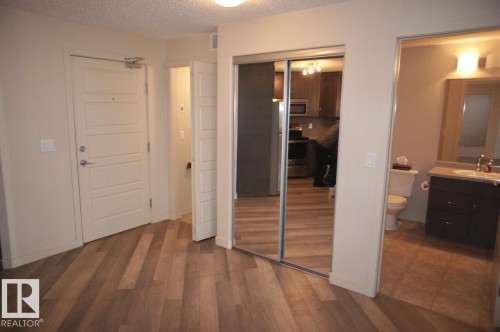 Modern wood-finish flooring extending from the entryway - 326 6076 Schonsee Way, Edmonton, AB - Indoor Photo Showing Other Room