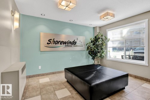 Entryway featuring light blue accent wall, recessed lighting, and rectangular ceiling light fixtures - 326 6076 Schonsee Way, Edmonton, AB - Indoor Photo Showing Other Room