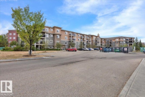 Multi-story building featuring varied facade materials including stone accents, siding, and stucco - 326 6076 Schonsee Way, Edmonton, AB - Outdoor With Balcony With Facade