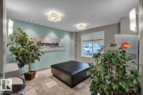 Lobby area featuring mixed tile flooring, a window with blinds, recessed lighting, and wall sconces - 326 6076 Schonsee Way, Edmonton, AB - Indoor Photo Showing Other Room