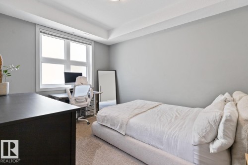 This room features a window providing natural light, light gray walls, and carpeting - 406 10811 72 Avenue, Edmonton, AB - Indoor Photo Showing Bedroom