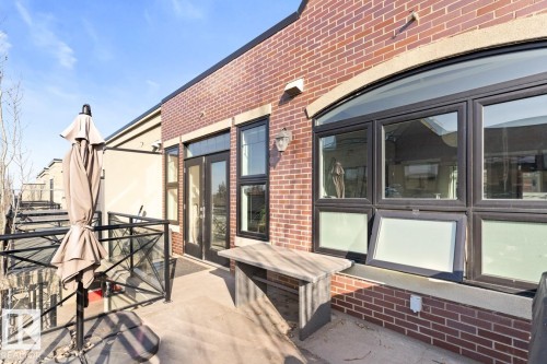 The property includes a private patio with a glass railing and a brick exterior facade - 406 10811 72 Avenue, Edmonton, AB - Outdoor