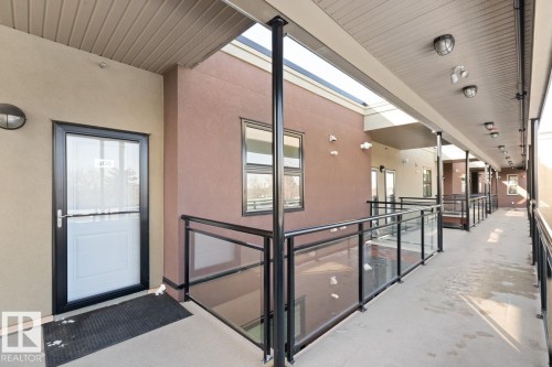 The property features exterior access to the unit, a glass railing, and exterior wall lighting - 406 10811 72 Avenue, Edmonton, AB - Outdoor With Balcony With Exterior